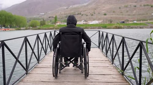 Man in a wheelchair near the lake
