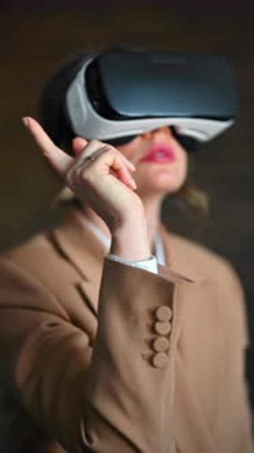 Woman gesturing while using a Virtual Reality headset in an office. Vertical