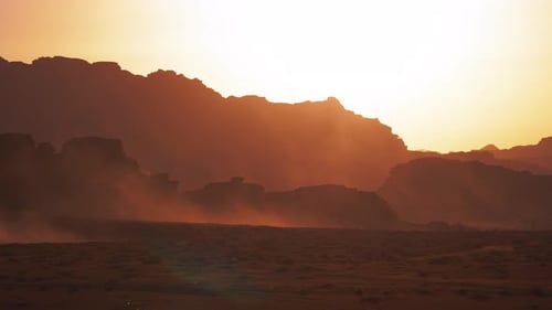 Desert Landscape with Rock Formations Silhouetted Against the Sky at Sunrise or Sunset with Dust