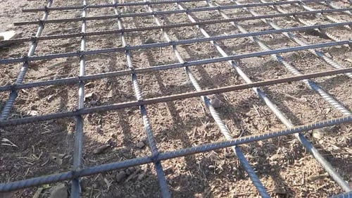 Les ouvriers attachaient à la main des barres d'armature en acier, serraient le fil sur les barres d'armature à l'aide de pinces pour le coffrage c