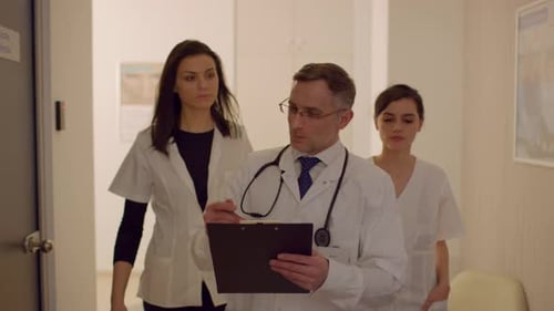 Doctors Walking and Talking in Hospital Hallway