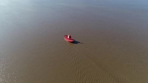 Eine leuchtend rote Markierungsboje im Fluss, die einen sicheren Schifffahrtskanal für die Schifffahrt hervorhebt, wo s