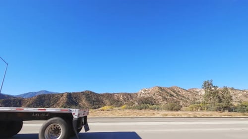 POV Passing semitrucks on mountain highway with blue sky