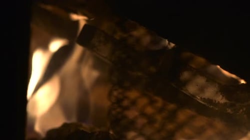 A rack focus into a burning fireplace in slow motion.