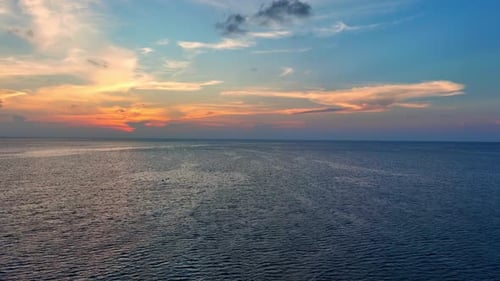 Drone aerial view of endless horizon over the sea in sunset. 4K.