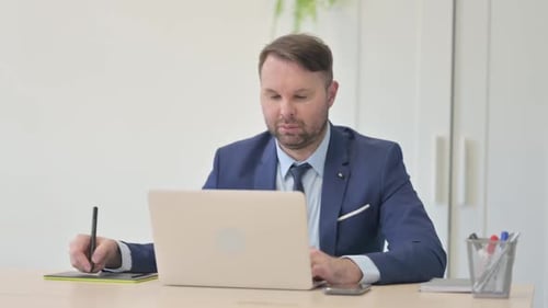 Businessman Working on Laptop and Graphic Tablet, Designing