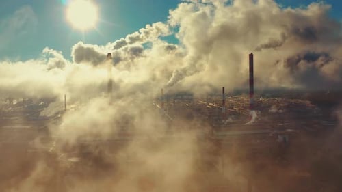 Power plant smokes. Aerial view of the power plant with smoking pipes and clouds passing by