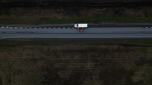 A Vehicle Driving on an Asphalt Highway at Night Surrounded By Grassland