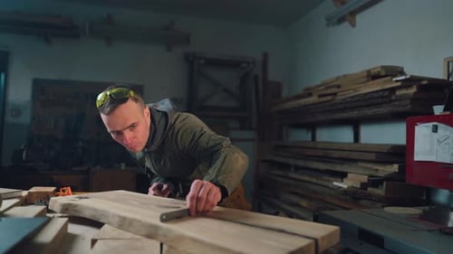 Adult Man Measuring Wood in a Workshop