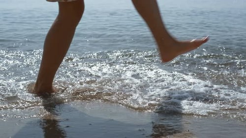 Unknown Active Woman Jumping on Sea Waves Lighted Sunlight Close Up. Legs