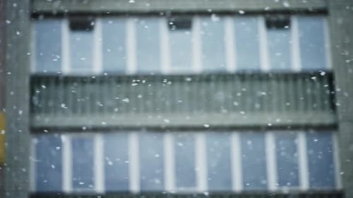 Snow Falling in Front of Apartment Building
