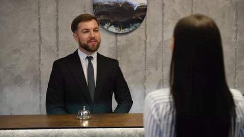 Hotel Receptionist Giving Room Key Card to Guest