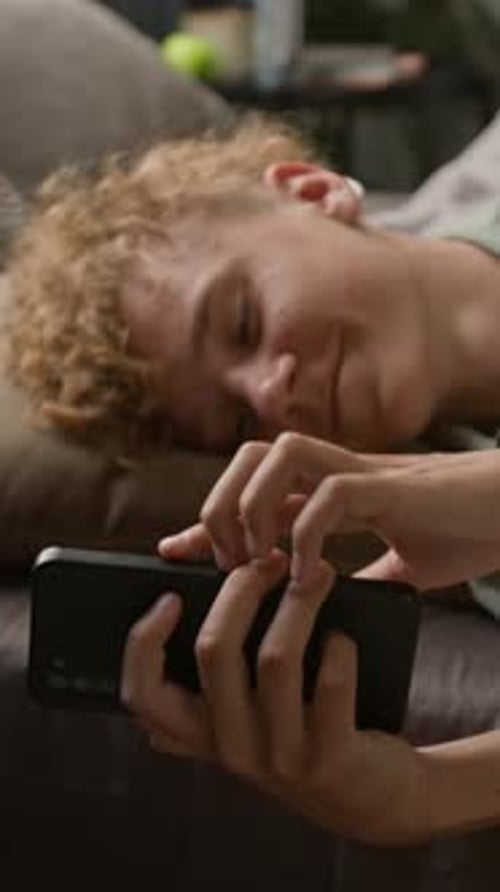 Teen Relaxing on Bed Using Mobile Phone