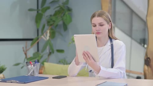 Young Doctor Browsing Tablet in Clinic