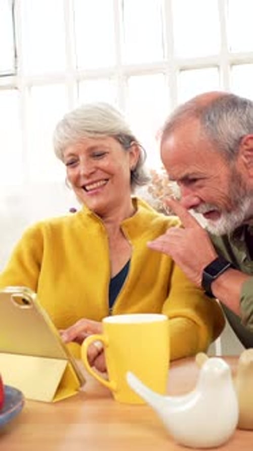 Mature Couple Using Digital Tablet Enjoying Time Together at Home