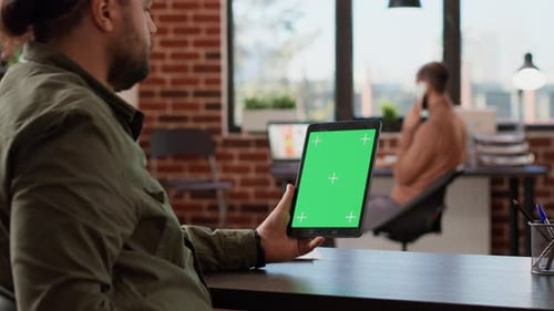 Adult Holding Tablet with Green Screen in Office