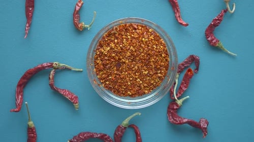 Top View of Rotating Chili Flakes in a Bowl on Table
