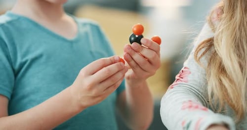 Child Builds Molecule Model at Table