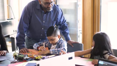Father Watching Kids Coloring and Playing with Toys at Dining Table 1011 Years