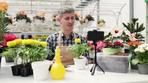 Man Films Plant Care Video in Greenhouse
