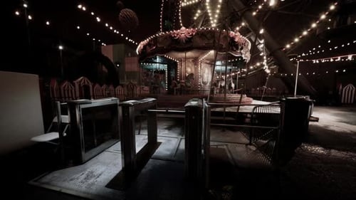 Empty Amusement Park at Night with Illuminated Rides and Closed Entrance