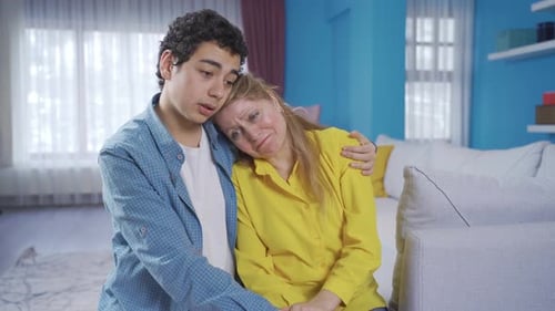 Der Sohn tröstet seine Mutter. Weinende traurige Mutter.