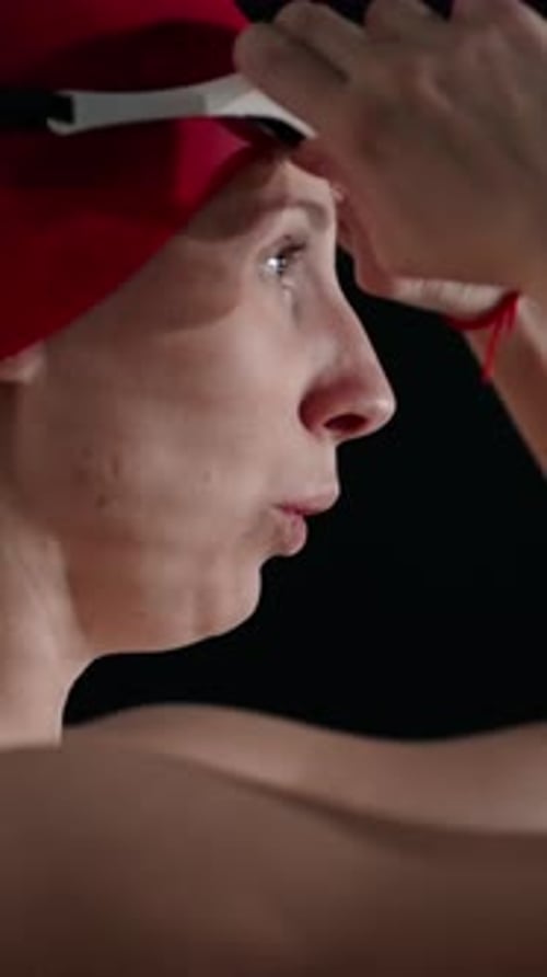 Woman Puts on Goggles in Preparation to Swim