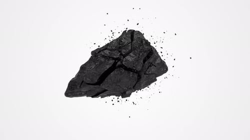 Black stone coal cracking and exploding in slow motion on a white background