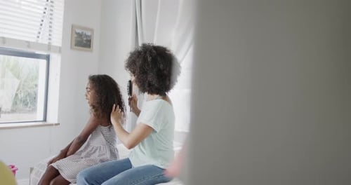 Adult Brushing Girl's Hair at Home