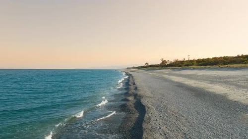 Tropical Beach at Sunset Near a Flat Empty Ocean
