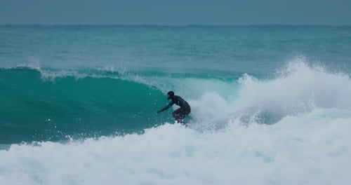 Surfer in Wetsuit Rides on Wave in Cold Ocean Winter Surfing with Perfect Waves