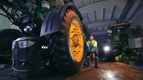 Der Meister zieht die Radmuttern des Traktors fest