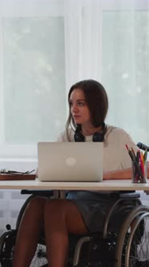 Disabled Woman Talks to Friend While Doing Task on Laptop