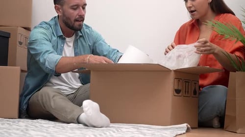 Couple Unpacking Boxes in New Home Together