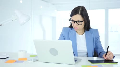 Woman Using Graphics Tablet at Desk in Office