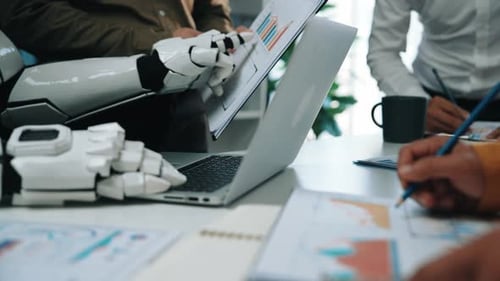 Robot typing on laptop with team reviewing charts