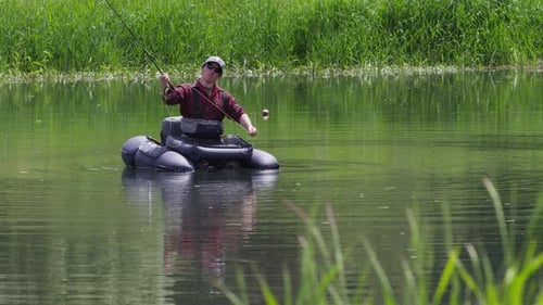 Man Fishing in Pond on Inflatable Boat
