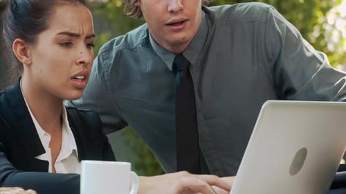 Young Professionals Collaborating on Laptop in Outdoor Workspace