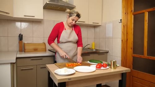 Woman Cutting Vegetables in Kitchen