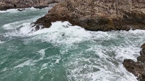 Dynamic Ocean Waves Crashing on Black Stones with Strong Motion