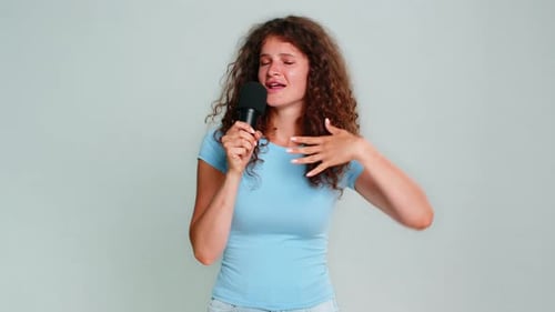 Expressive Woman Singing Passionately Into Microphone in Studio