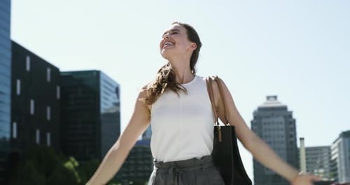 Woman Celebrates in City Center on Sunny Day