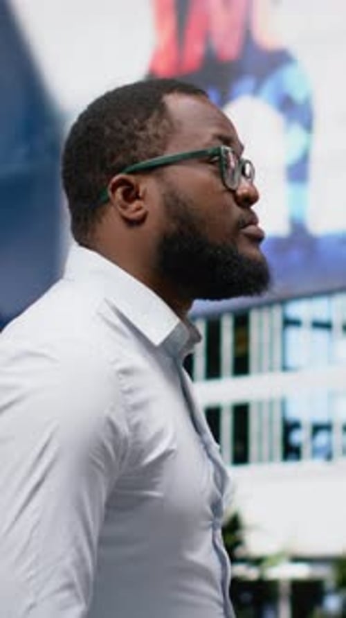 Vertical Video Black Adult Male with Trendy Style and Dynamic Attitude Walks a Downtown Street