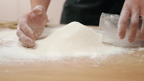 Close Up Hands Mixing Flour with Measuring Cup