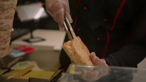Chef making pita with roasted chicken meat on table - summer food market. Cooking, gastronomy