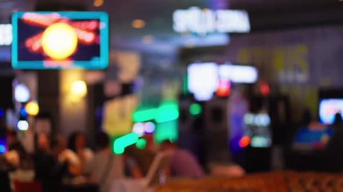 Experience the Lively and Vibrant Atmosphere of a Casino Filled with Blurred Slot Machines and