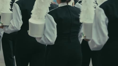 Cinematic high school marching band members walking by in slow motion