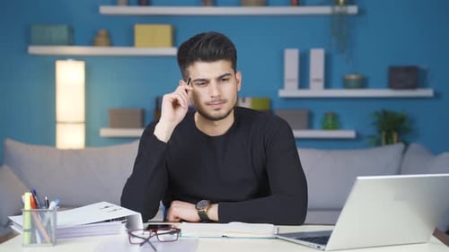 Thoughtful businessman working in his home office and coming up with a good idea.