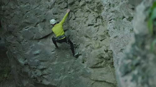 Jung fit Männlicher Tourist Klettern Vorsichtiger Steinfelsen im Freien Aktiver Sportler Kletterer bewegt sich den