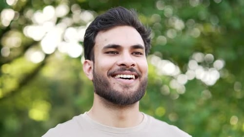 Happy young adult sportsman relaxing with closed eyes standing in urban city park. A smiling handsom